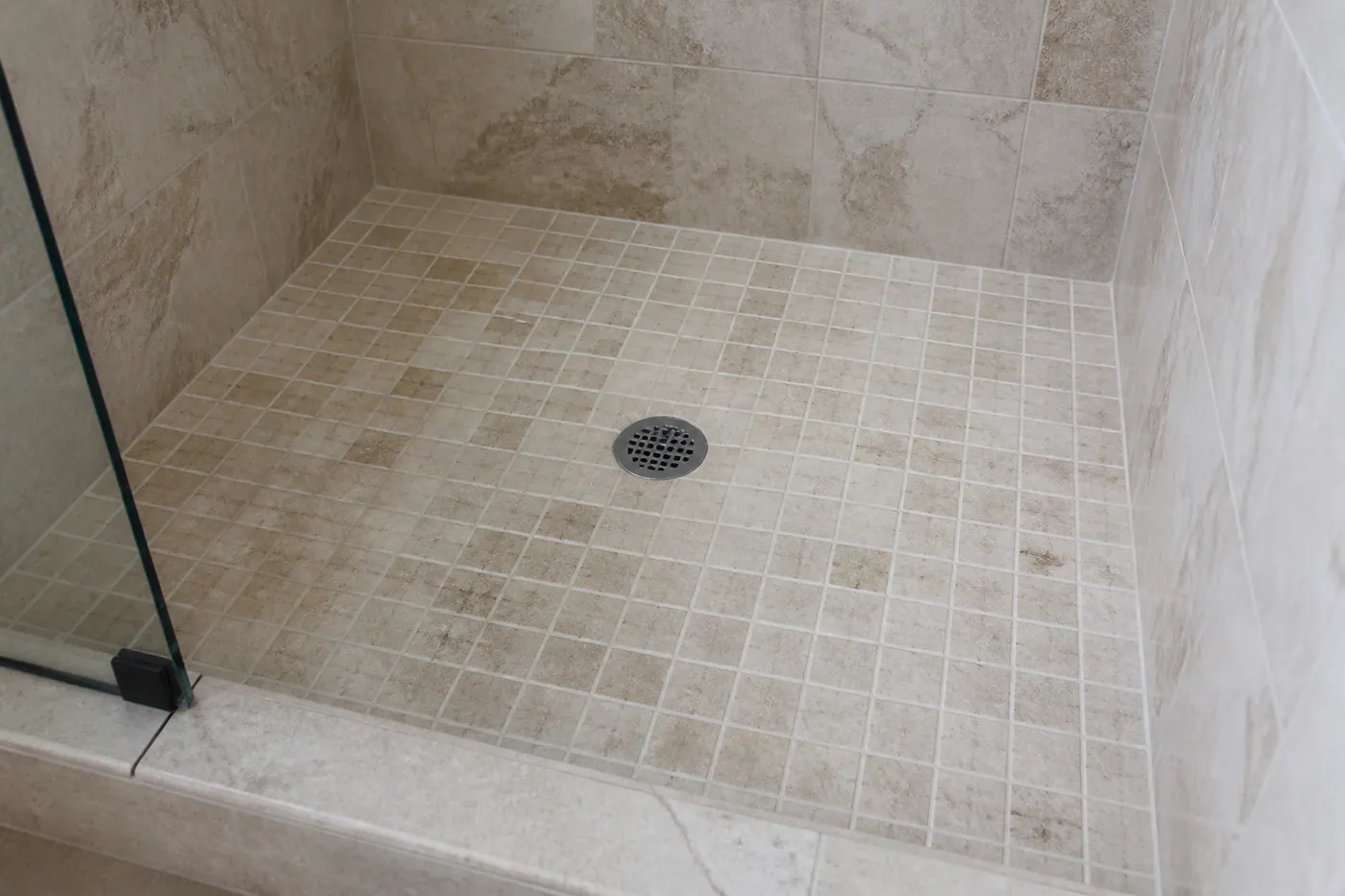 Shower drain clogged with hair and soap scum